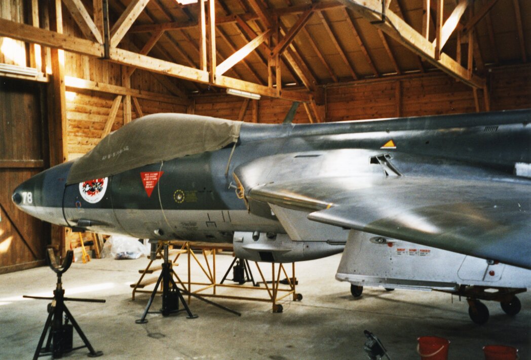 Bénévoles réunis dans un hangar d’aviation autour d’un avion en cours de restauration