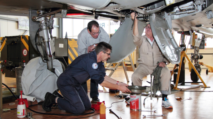 Bénévoles travaillant sur la restauration d’un avion dans un atelier de musée