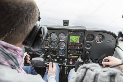 Visiteurs assis dans le cockpit d’un avion de chasse dans un musée