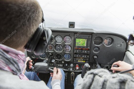 Visiteurs assis dans le cockpit d’un avion de chasse dans un musée